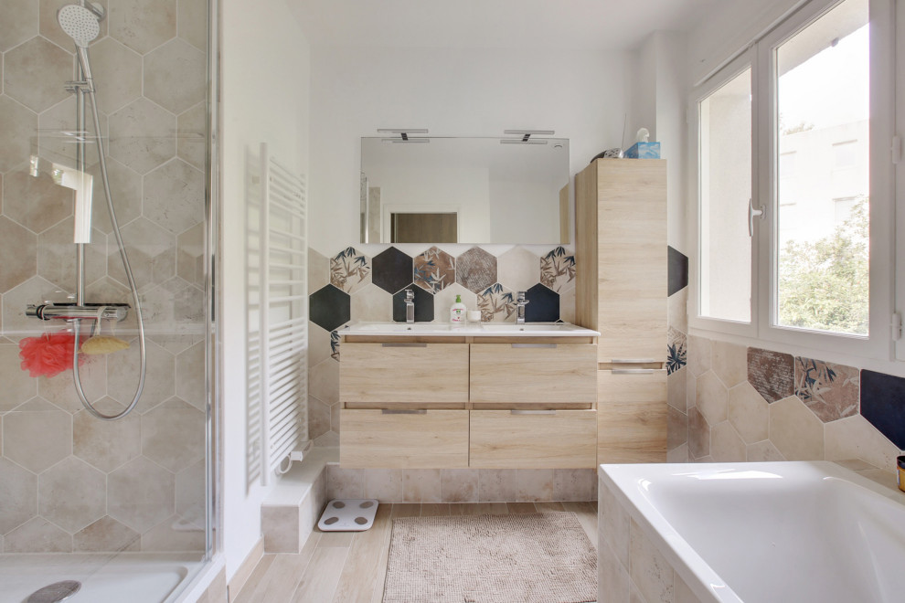 Свежая идея для дизайна: главная ванная комната среднего размера в современном стиле с плоскими фасадами, светлыми деревянными фасадами, отдельно стоящей ванной, двойным душем, раздельным унитазом, бежевой плиткой, коричневой плиткой, черной плиткой, керамической плиткой, белыми стенами, полом из ламината, подвесной раковиной, бежевым полом, душем с распашными дверями и белой столешницей - отличное фото интерьера
