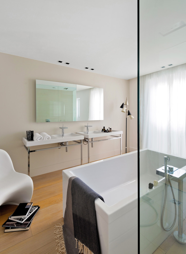 На фото: ванная комната в современном стиле с отдельно стоящей ванной, бежевыми стенами, паркетным полом среднего тона, консольной раковиной и коричневым полом