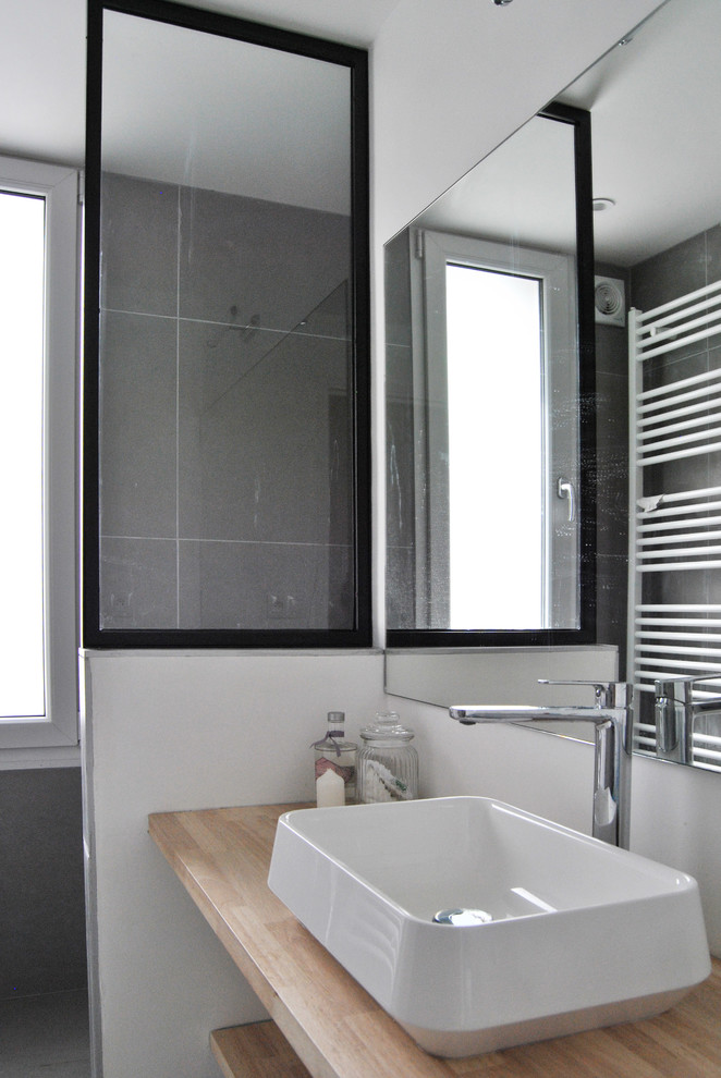 Foto på ett mellanstort minimalistiskt badrum för barn, med en öppen dusch, grå kakel, keramikplattor, grå väggar, ett nedsänkt handfat, träbänkskiva, grått golv och med dusch som är öppen