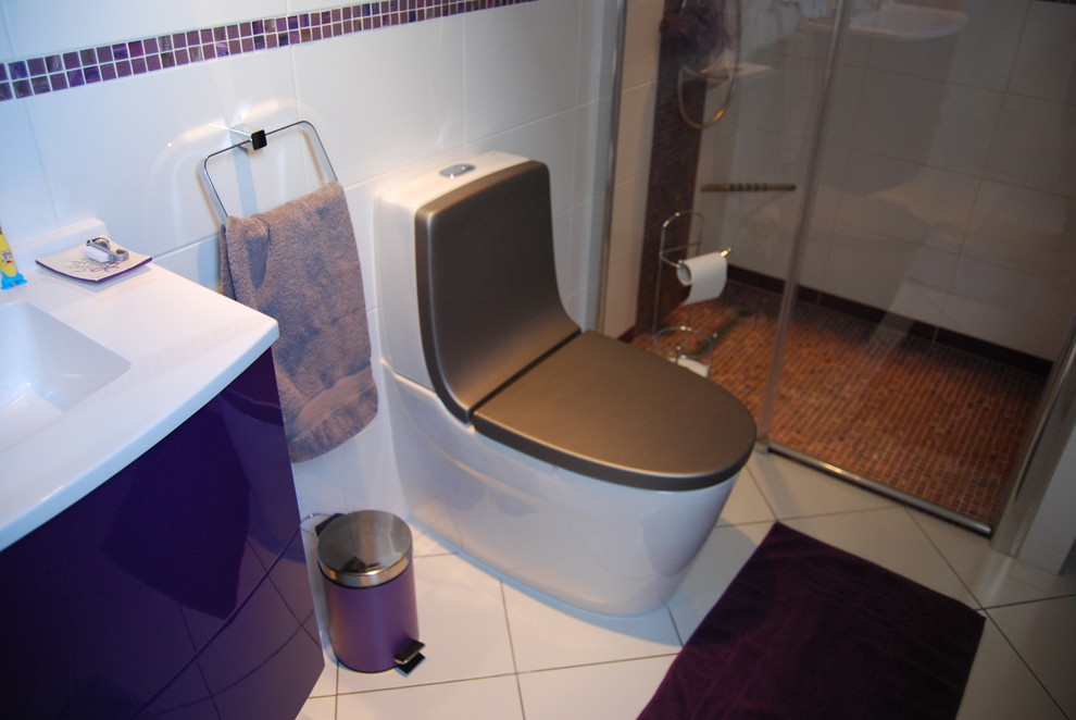 На фото: главная ванная комната среднего размера в современном стиле с плоскими фасадами, фиолетовыми фасадами, душем без бортиков, унитазом-моноблоком, белой плиткой, керамической плиткой, серыми стенами, полом из керамической плитки, консольной раковиной и столешницей из ламината