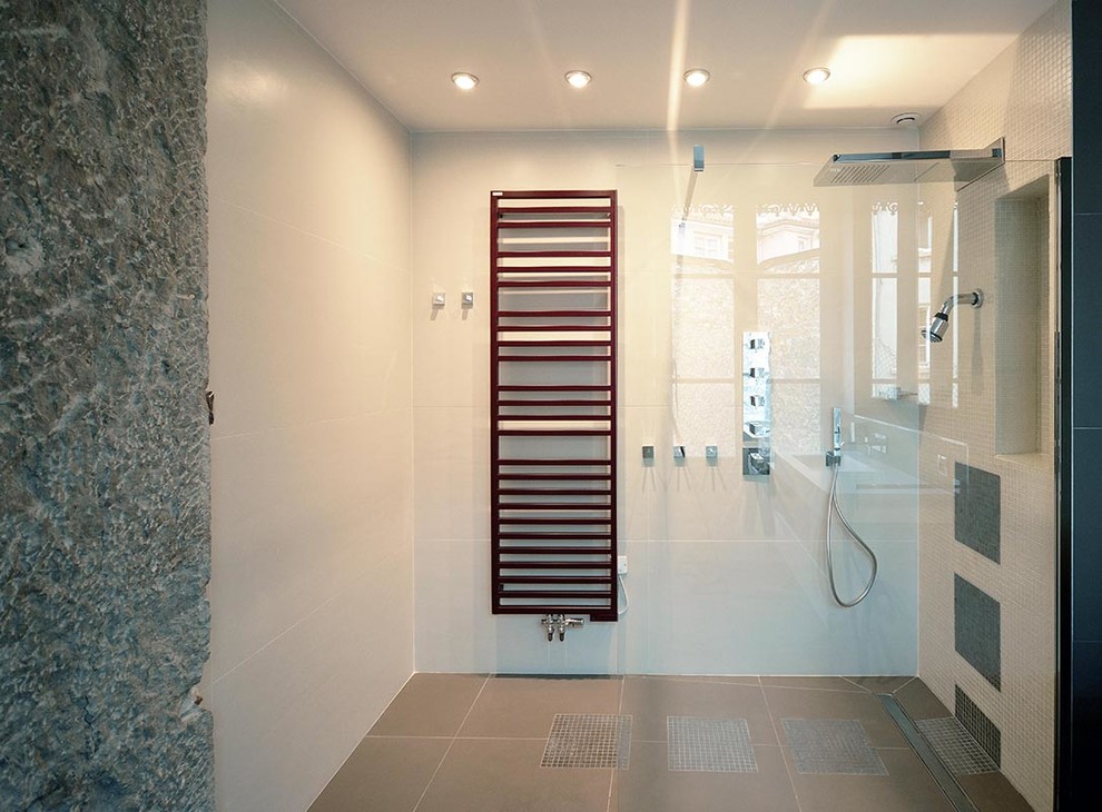Cette image montre une salle de bain principale design avec une douche à l'italienne, WC suspendus, un carrelage gris, des carreaux de céramique, un mur beige, un sol en carrelage de céramique, un plan vasque et un plan de toilette en surface solide.