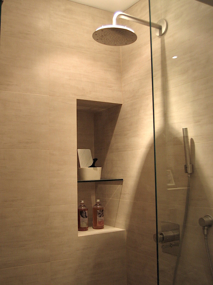 Idée de décoration pour une petite salle d'eau design en bois clair avec un placard à porte plane, une douche double, WC suspendus, un carrelage beige, un carrelage de pierre, un mur beige, un plan vasque, un sol beige et une cabine de douche à porte coulissante.