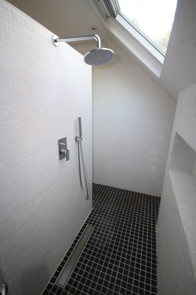 Inspiration för ett stort funkis vit vitt badrum med dusch, med en kantlös dusch, vit kakel, vita skåp, en vägghängd toalettstol, tunnelbanekakel, vita väggar, klinkergolv i keramik, ett nedsänkt handfat, träbänkskiva, svart golv och med dusch som är öppen