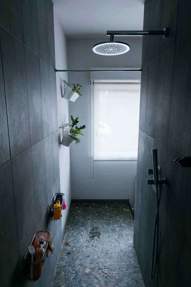 Esempio di una stanza da bagno con doccia design di medie dimensioni con doccia aperta, piastrelle grigie, piastrelle in ceramica, pareti bianche, pavimento con piastrelle di ciottoli, lavabo integrato, pavimento grigio e doccia aperta