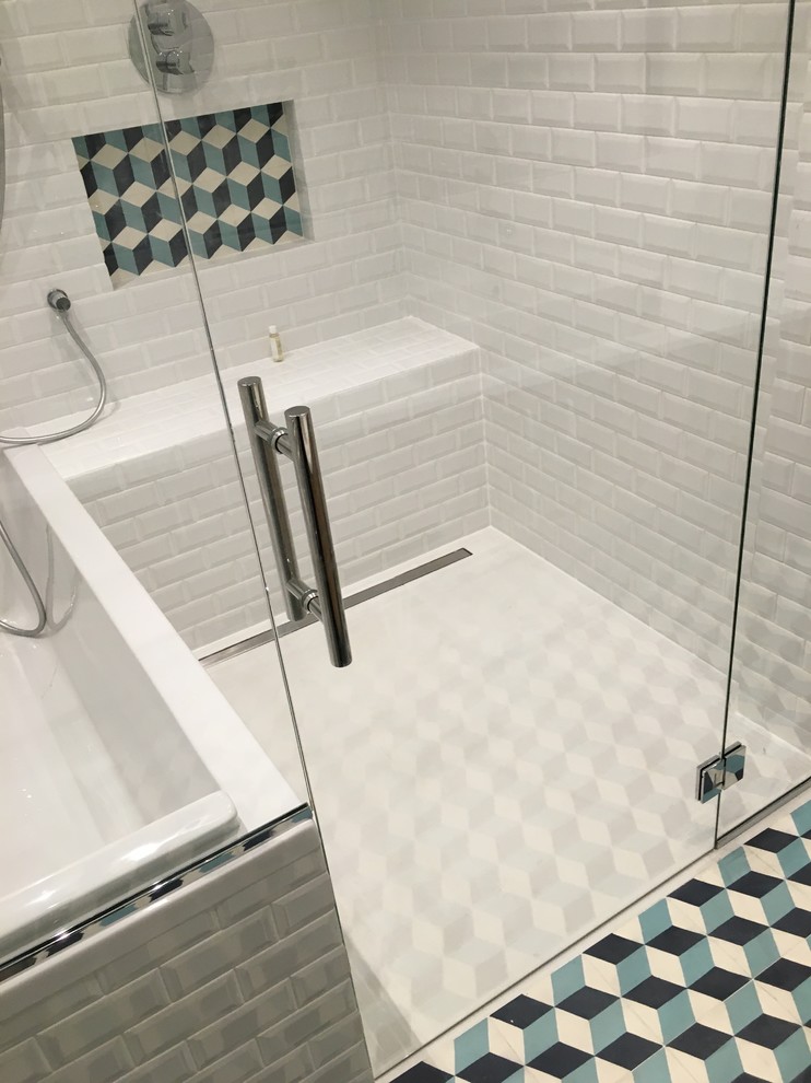 パリにある高級な中くらいなコンテンポラリースタイルのおしゃれなマスターバスルーム (フラットパネル扉のキャビネット、淡色木目調キャビネット、アンダーマウント型浴槽、バリアフリー、白いタイル、サブウェイタイル、白い壁、セメントタイルの床、コンソール型シンク、ステンレスの洗面台、青い床、開き戸のシャワー) の写真