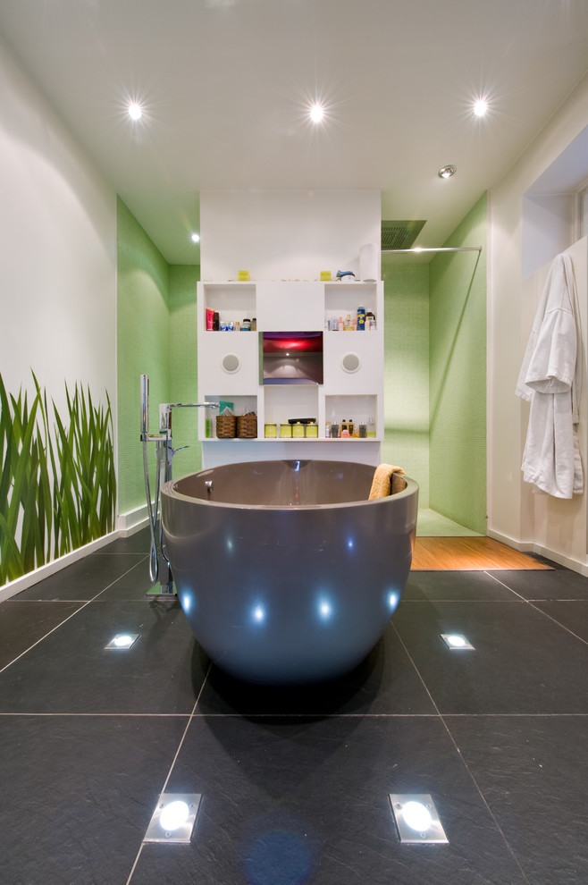 Photo of a medium sized contemporary ensuite bathroom in Paris with a trough sink, glass worktops, a freestanding bath, a built-in shower, a wall mounted toilet, green tiles, mosaic tiles and white walls.
