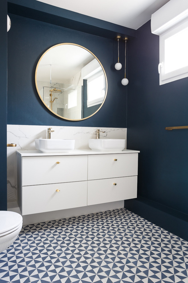 Пример оригинального дизайна: большая главная ванная комната в современном стиле с плоскими фасадами, белыми фасадами, инсталляцией, белой плиткой, керамической плиткой, синими стенами, полом из керамической плитки, настольной раковиной, столешницей из искусственного камня, синим полом, душем с распашными дверями, белой столешницей, тумбой под две раковины и подвесной тумбой