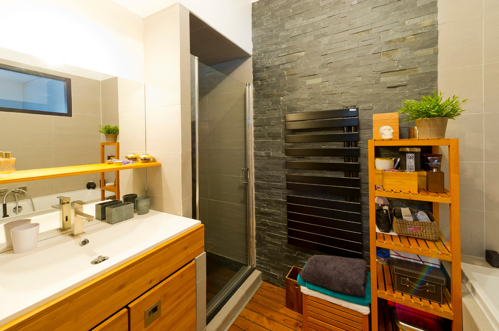 Idéer för funkis badrum, med ett undermonterat badkar, en kantlös dusch, grå kakel, porslinskakel, vita väggar, mörkt trägolv, ett undermonterad handfat och bänkskiva i kvartsit