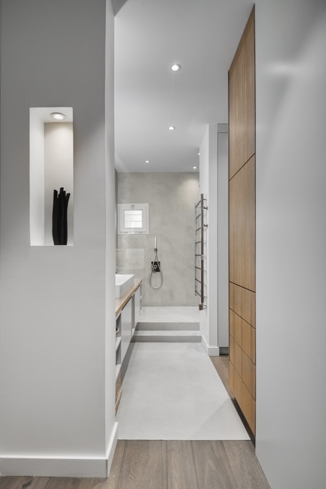 Inspiration pour une salle de bain principale, longue et étroite et blanche et bois design avec des portes de placard marrons, une douche ouverte, un carrelage gris, un mur blanc, un lavabo intégré, un sol blanc, meuble simple vasque et meuble-lavabo encastré.