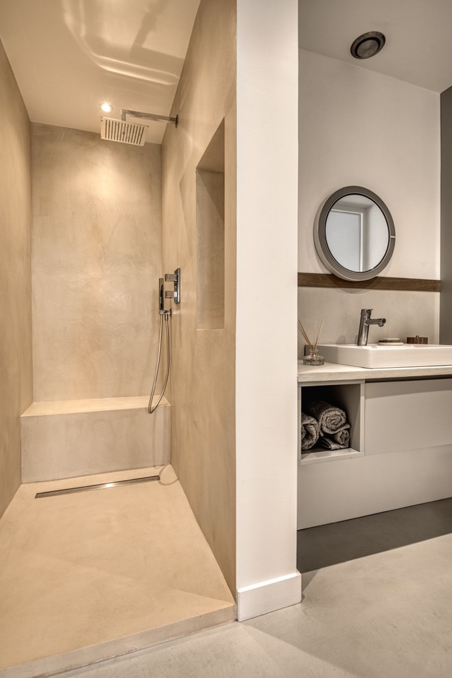 Réalisation d'une douche en alcôve principale design avec des portes de placard blanches, un carrelage gris, un mur blanc, un lavabo intégré, un sol beige, une niche et meuble simple vasque.