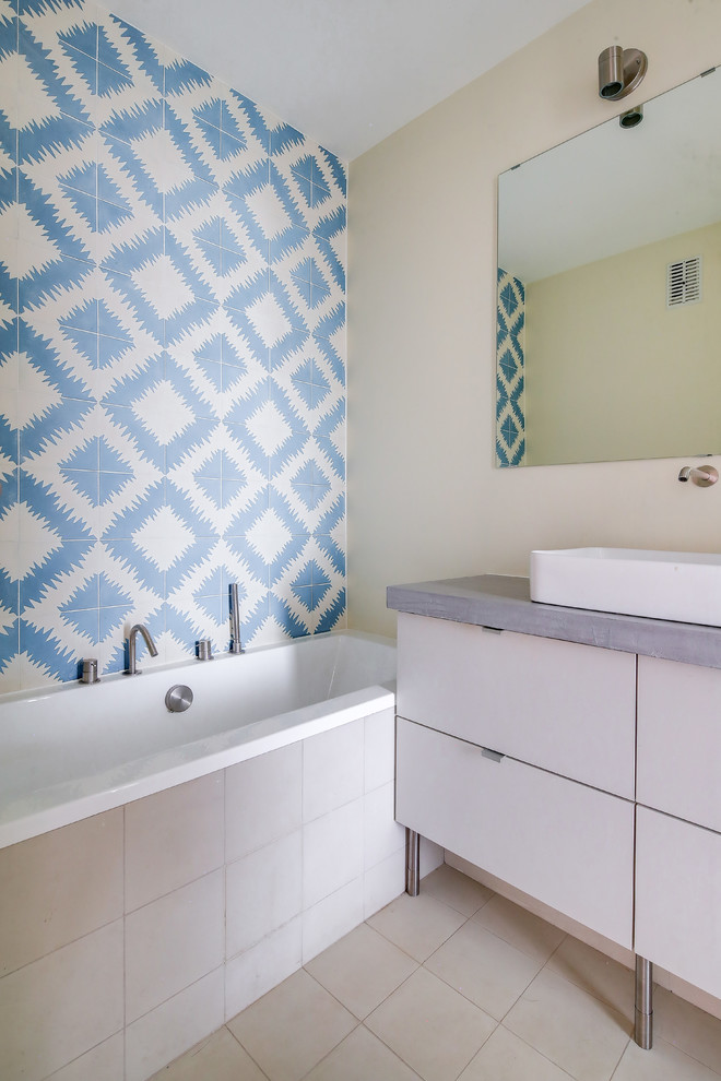 Mid-sized trendy master blue tile and cement tile cement tile floor and gray floor bathroom photo in Paris with beaded inset cabinets, gray cabinets, beige walls, a console sink, concrete countertops, gray countertops and a two-piece toilet