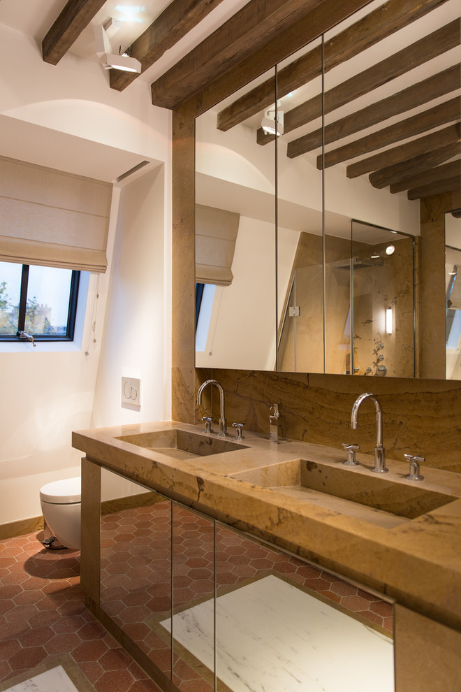 Example of a tuscan terra-cotta tile and red floor bathroom design in Paris with flat-panel cabinets, white walls, an integrated sink, a hinged shower door and brown countertops