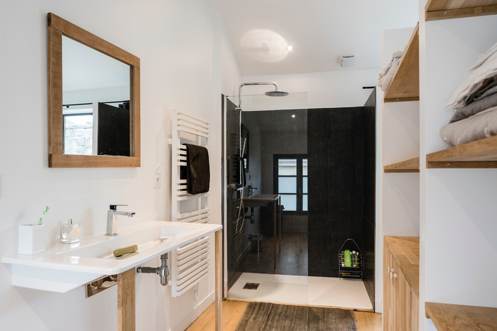 Cette image montre une salle de bain principale minimaliste avec une douche à l'italienne, un mur blanc, parquet clair et un lavabo de ferme.