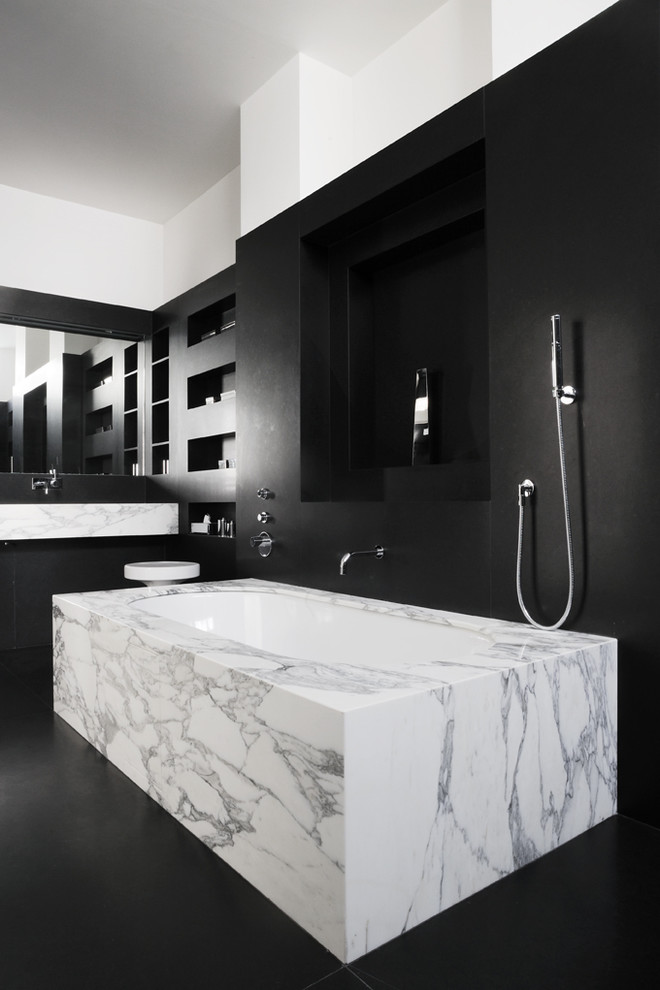 Idée de décoration pour une salle de bain principale minimaliste de taille moyenne avec une baignoire encastrée, un combiné douche/baignoire, un mur noir et un lavabo suspendu.
