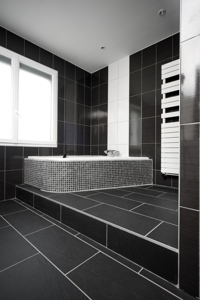 Inspiration för ett funkis badrum, med ett hörnbadkar, svart kakel, svarta väggar och svart golv