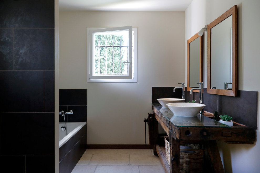 Foto di una stanza da bagno padronale moderna con vasca sottopiano, piastrelle grigie, pareti bianche, lavabo a bacinella, top in vetro, pavimento beige e top marrone