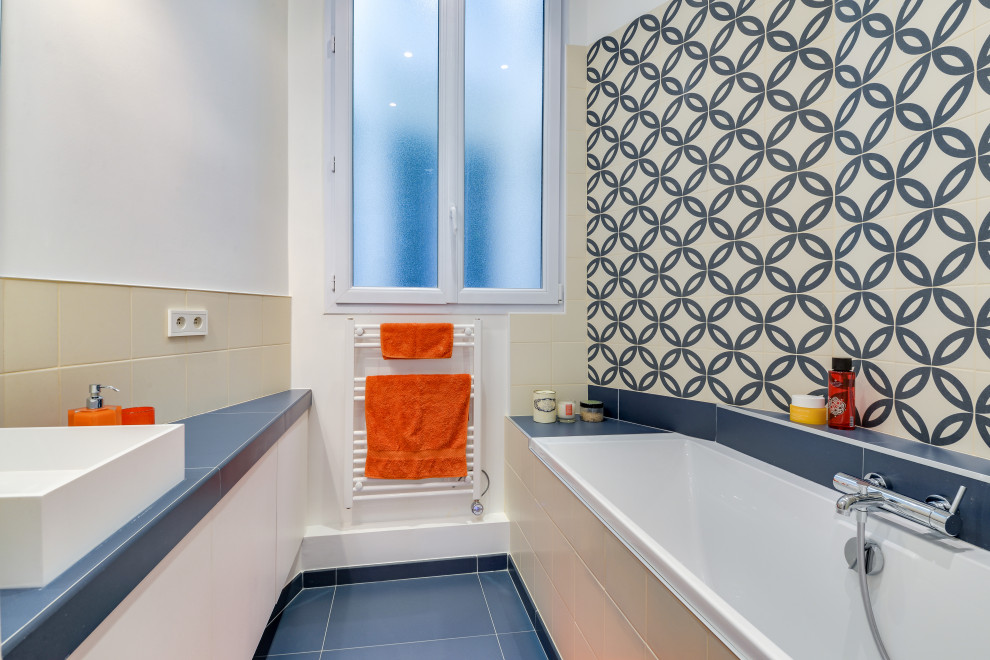Foto på ett litet funkis blå badrum med dusch, med släta luckor, vita skåp, ett platsbyggt badkar, beige kakel, blå kakel, porslinskakel, vita väggar, klinkergolv i porslin, ett fristående handfat och blått golv