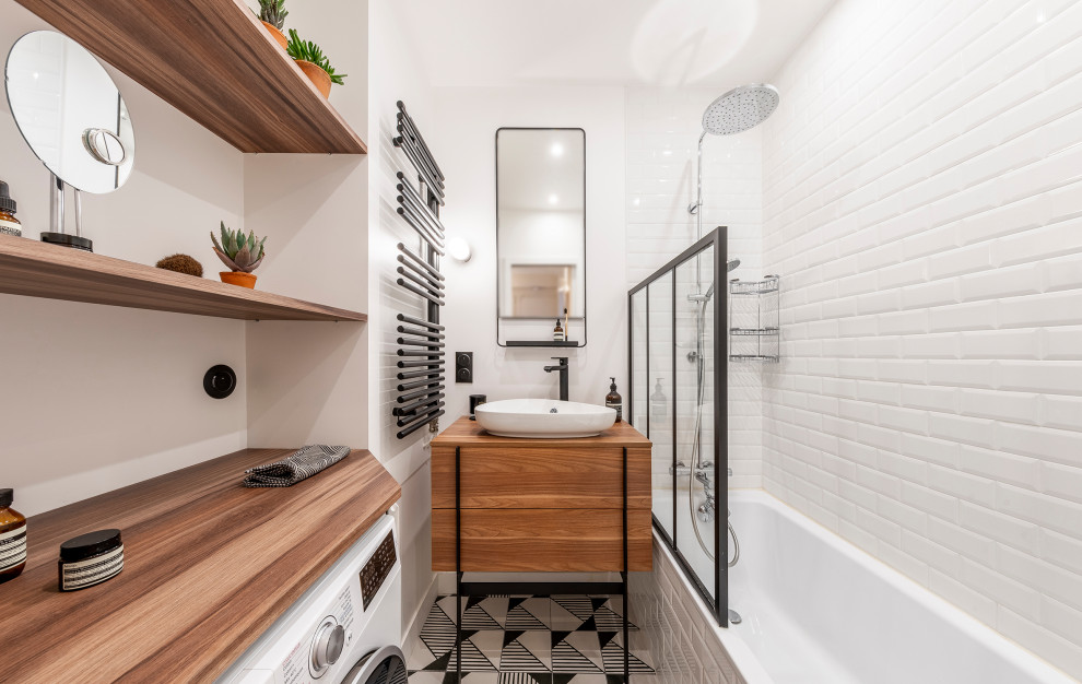 This is an example of a small contemporary ensuite bathroom in Paris with flat-panel cabinets, white cabinets, a submerged bath, white tiles, metro tiles, white walls, cement flooring, a built-in sink, laminate worktops, multi-coloured floors and brown worktops.