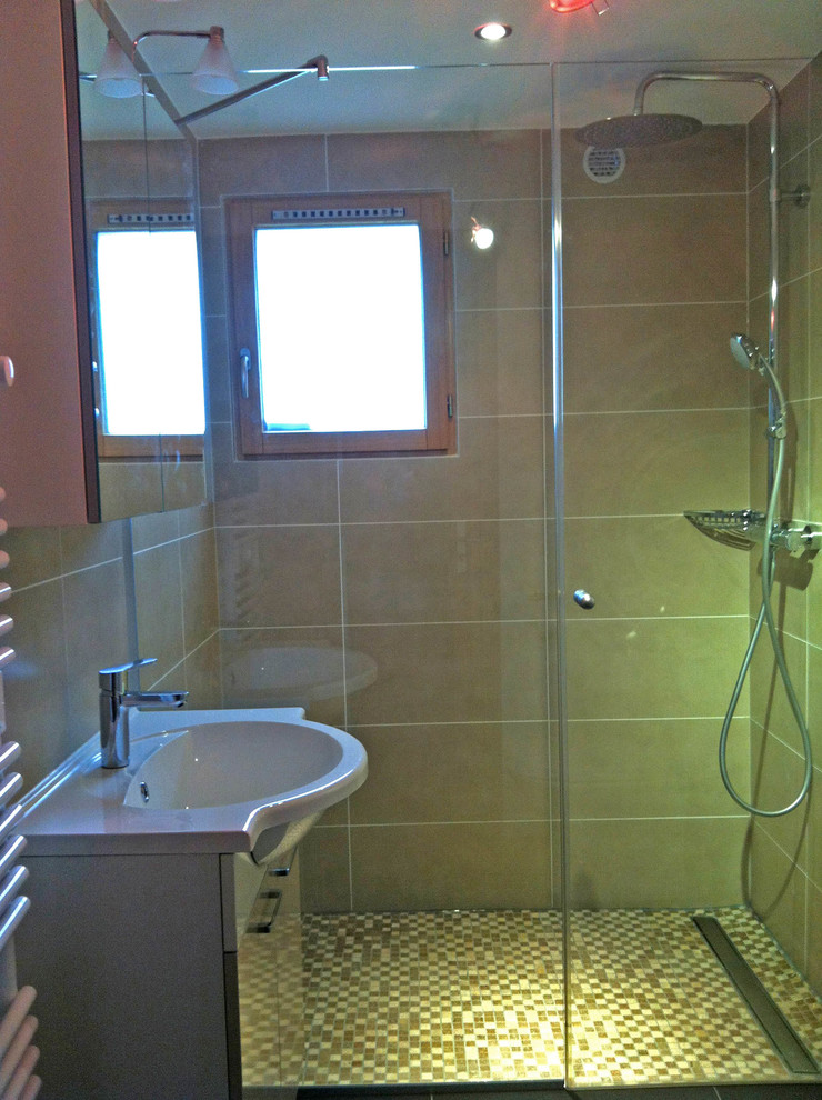 This is an example of a medium sized modern family bathroom in Lyon with light wood cabinets, a submerged bath, a built-in shower, beige tiles, beige walls and an integrated sink.
