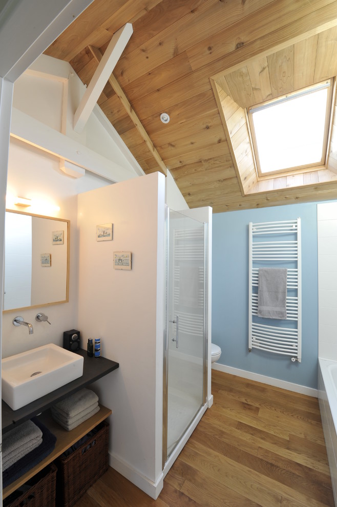Ispirazione per una stanza da bagno con doccia design di medie dimensioni con nessun'anta, ante nere, doccia alcova, pareti blu, pavimento in legno massello medio, lavabo a bacinella e top in legno