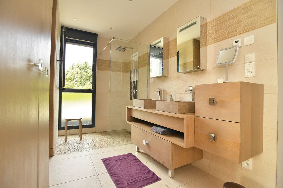 Modern inredning av ett mellanstort badrum, med skåp i mellenmörkt trä, en hörndusch, beige kakel, keramikplattor, beige väggar, klinkergolv i keramik, ett konsol handfat, träbänkskiva, med dusch som är öppen och släta luckor