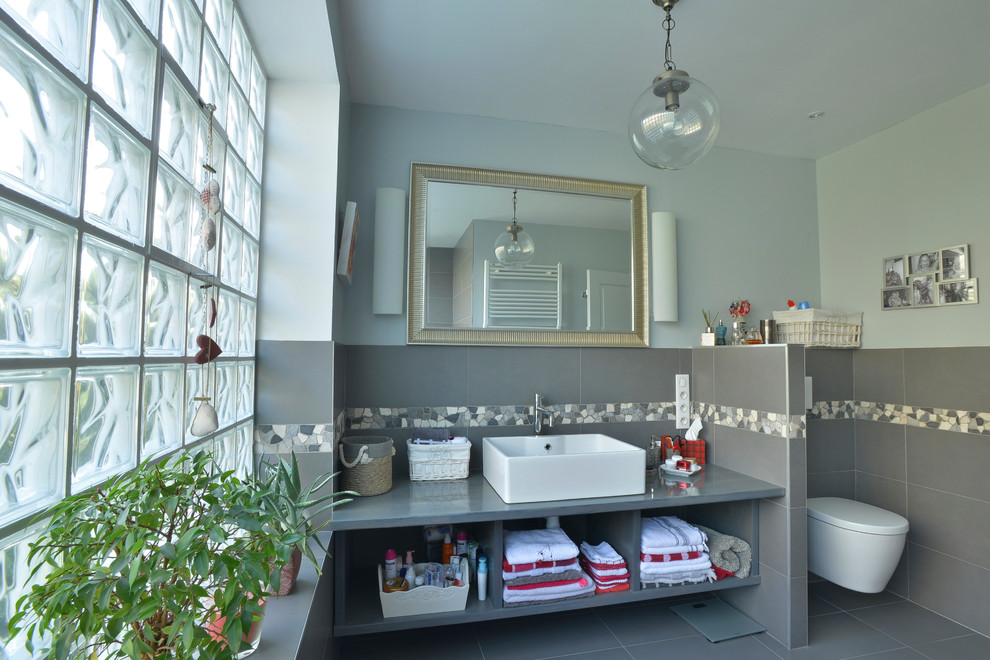 Источник вдохновения для домашнего уюта: ванная комната в стиле неоклассика (современная классика) с открытыми фасадами, серыми фасадами, инсталляцией, серой плиткой, керамической плиткой, синими стенами, полом из керамической плитки и накладной раковиной
