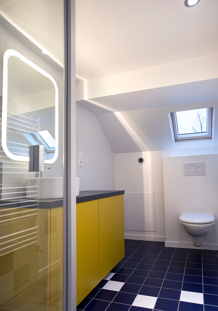 Пример оригинального дизайна: маленькая ванная комната в современном стиле с плоскими фасадами, желтыми фасадами, инсталляцией, синей плиткой, керамической плиткой, белыми стенами, полом из керамической плитки, душевой кабиной, настольной раковиной и столешницей из ламината для на участке и в саду