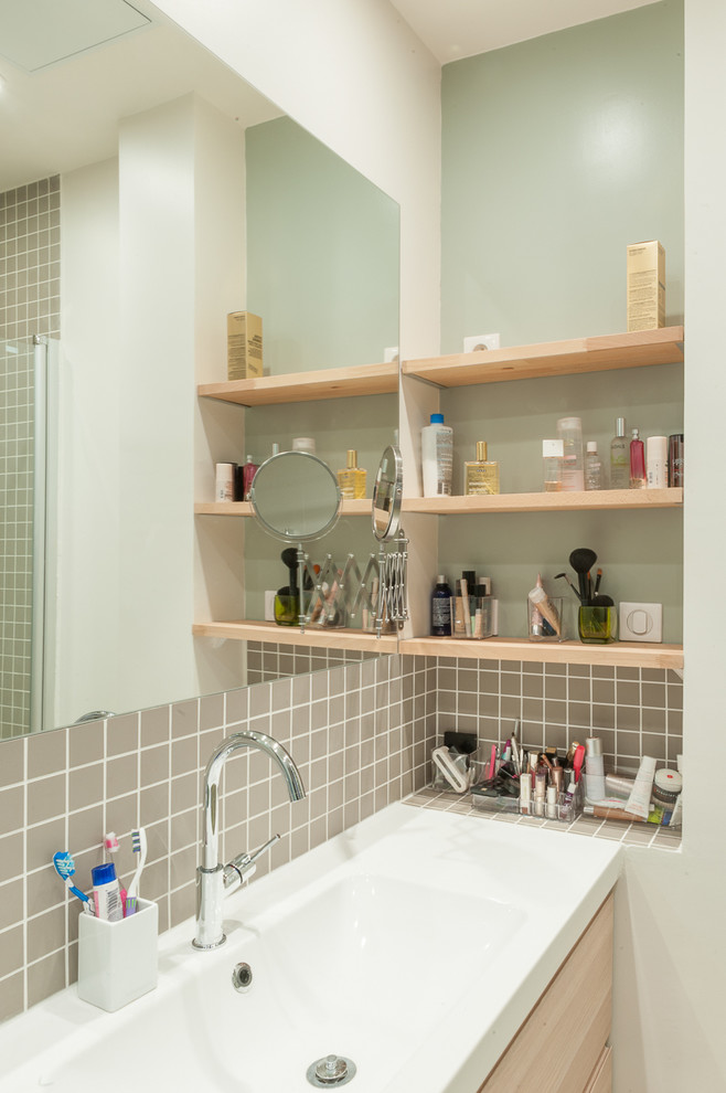 Exempel på ett litet modernt en-suite badrum, med luckor med profilerade fronter, skåp i ljust trä, ett undermonterat badkar, en dusch i en alkov, beige kakel, cementkakel, vita väggar, cementgolv och ett avlångt handfat
