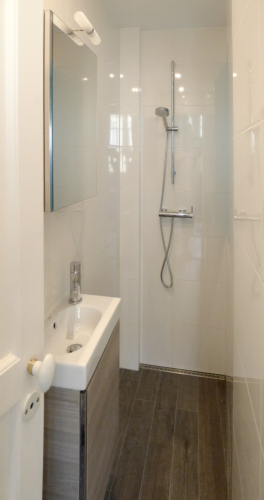 Aménagement d'une petite salle d'eau contemporaine avec une douche à l'italienne, un carrelage blanc, des carreaux de céramique, un mur blanc, un sol en bois brun et un lavabo posé.