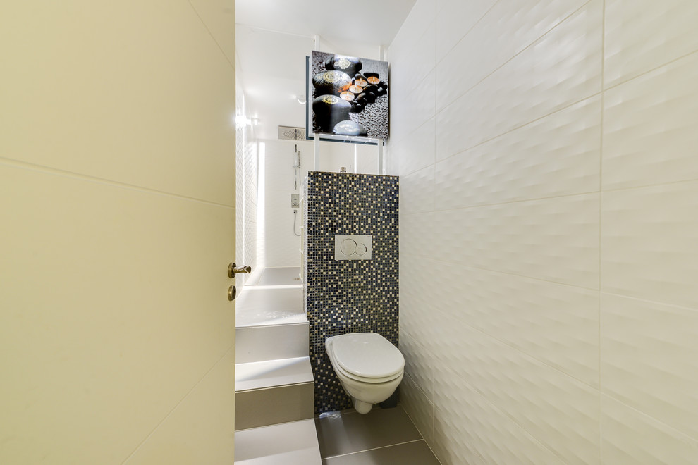Idée de décoration pour une petite salle d'eau design avec une douche à l'italienne, WC suspendus, un carrelage blanc, des carreaux de céramique, un mur blanc, un sol en carrelage de céramique, une grande vasque, un sol gris et aucune cabine.