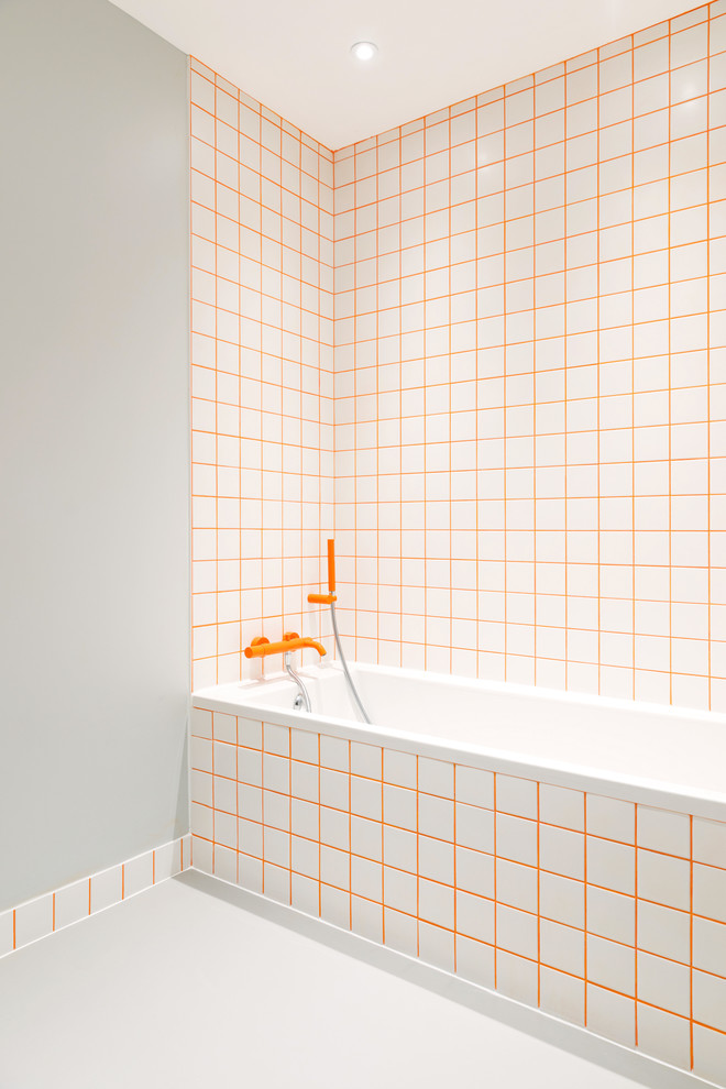 Идея дизайна: ванная комната в современном стиле с накладной ванной, оранжевой плиткой, серыми стенами и серым полом
