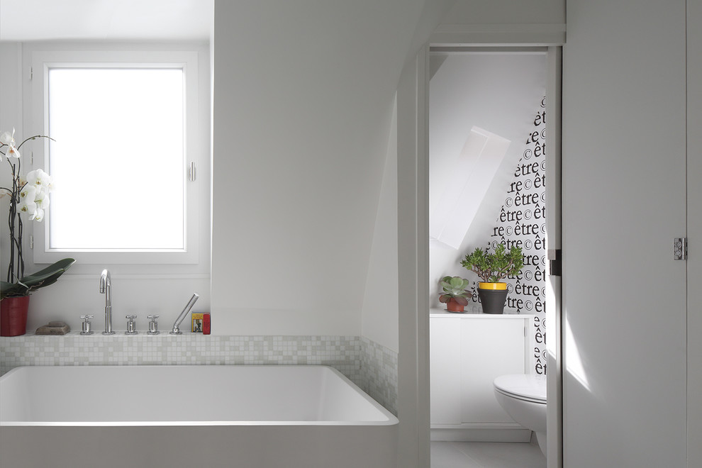 Idéer för att renovera ett litet funkis en-suite badrum, med vita skåp, ett fristående badkar, en dusch i en alkov, en toalettstol med separat cisternkåpa, vit kakel, mosaik, vita väggar, klinkergolv i keramik och ett väggmonterat handfat