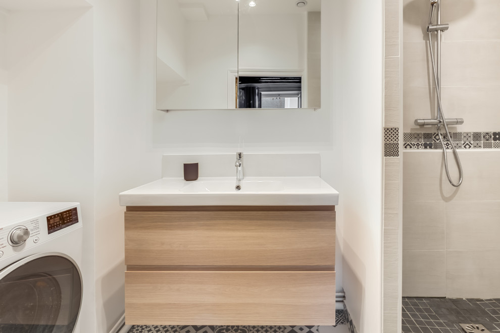 Cette image montre une salle de bain nordique en bois clair avec une douche d'angle, un carrelage beige, un carrelage blanc, un carrelage noir et blanc, des carreaux de béton, un mur blanc, un sol en carrelage de céramique, une grande vasque et un sol noir.