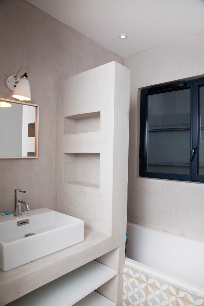 Пример оригинального дизайна: ванная комната в стиле модернизм с полновстраиваемой ванной, разноцветной плиткой, керамической плиткой, раковиной с несколькими смесителями и столешницей из бетона