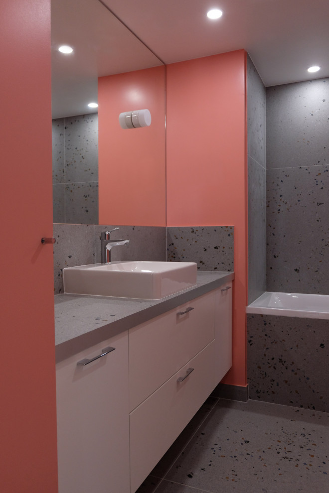 На фото: главная ванная комната среднего размера в современном стиле с плоскими фасадами, белыми фасадами, ванной в нише, керамической плиткой, розовыми стенами, полом из керамической плитки, накладной раковиной, столешницей из плитки, разноцветным полом и разноцветной столешницей с
