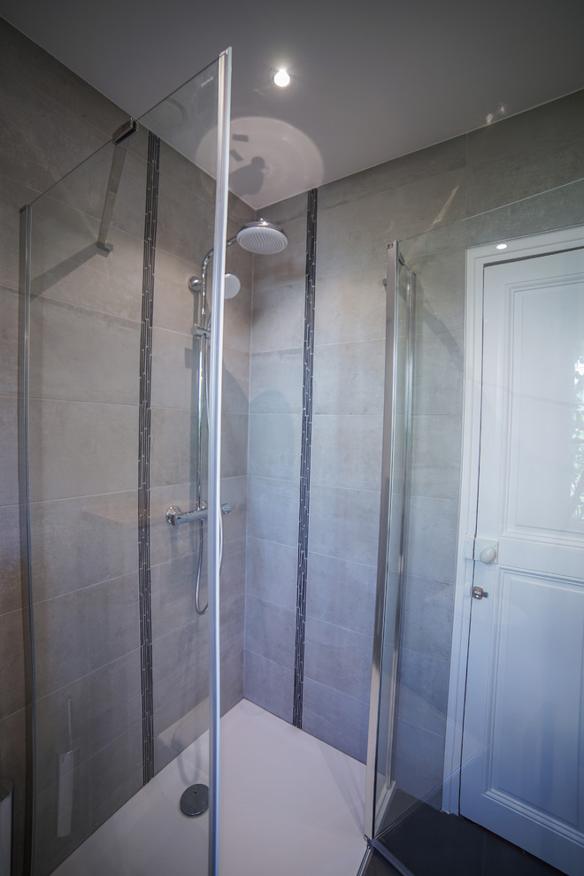 Inspiration för små moderna badrum med dusch, med luckor med profilerade fronter, skåp i ljust trä, en vägghängd toalettstol, grå kakel, porslinskakel, grå väggar, klinkergolv i porslin, ett undermonterad handfat, bänkskiva i kalksten, grått golv, dusch med gångjärnsdörr och en hörndusch