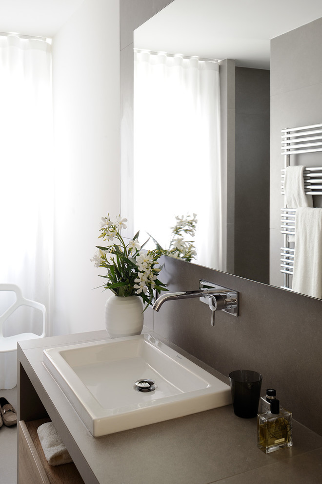 Ispirazione per una stanza da bagno con doccia contemporanea con piastrelle grigie, lavabo a consolle, top piastrellato e top grigio