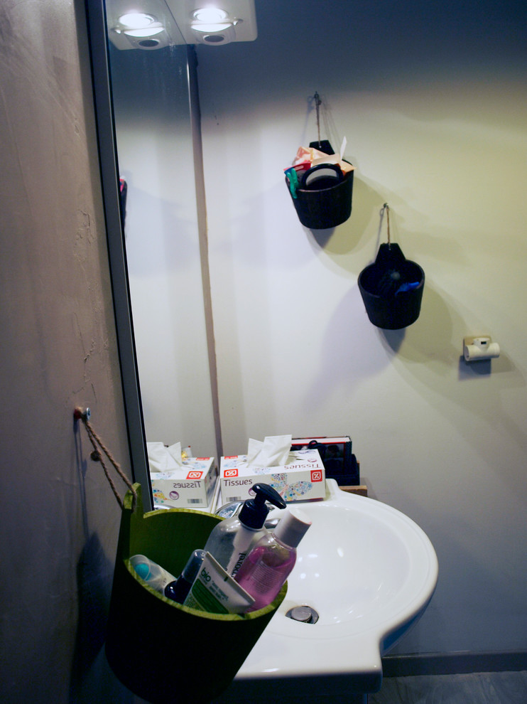 Immagine di una piccola stanza da bagno padronale minimalista con piastrelle marroni, pareti marroni, pavimento in vinile, lavabo a colonna, top in superficie solida, pavimento grigio e porta doccia scorrevole