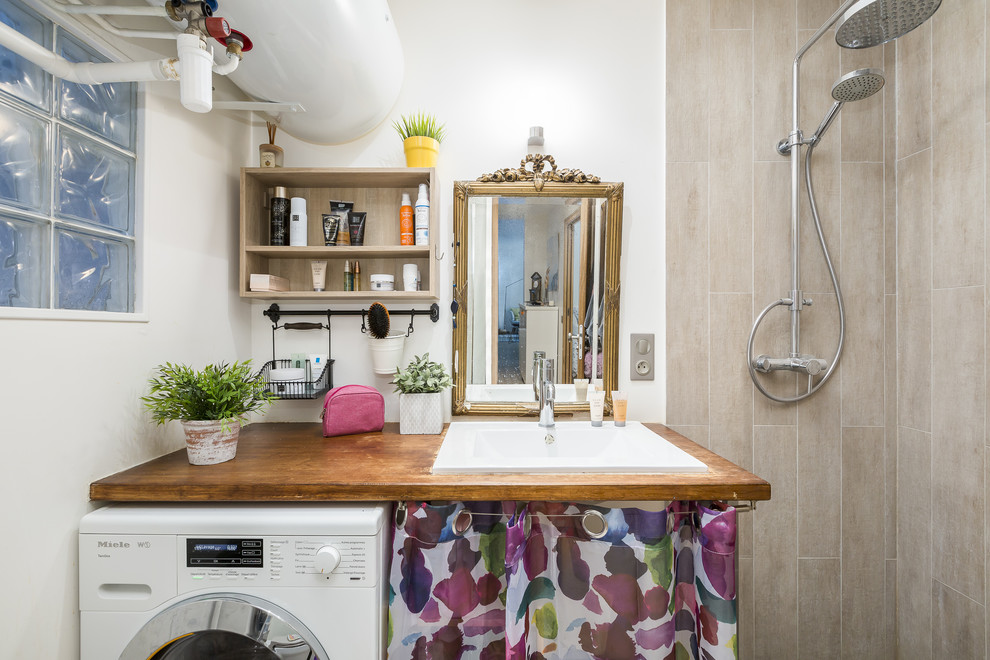 На фото: ванная комната со стиральной машиной в стиле фьюжн с бежевой плиткой, белыми стенами, накладной раковиной, столешницей из дерева, открытым душем и коричневой столешницей с