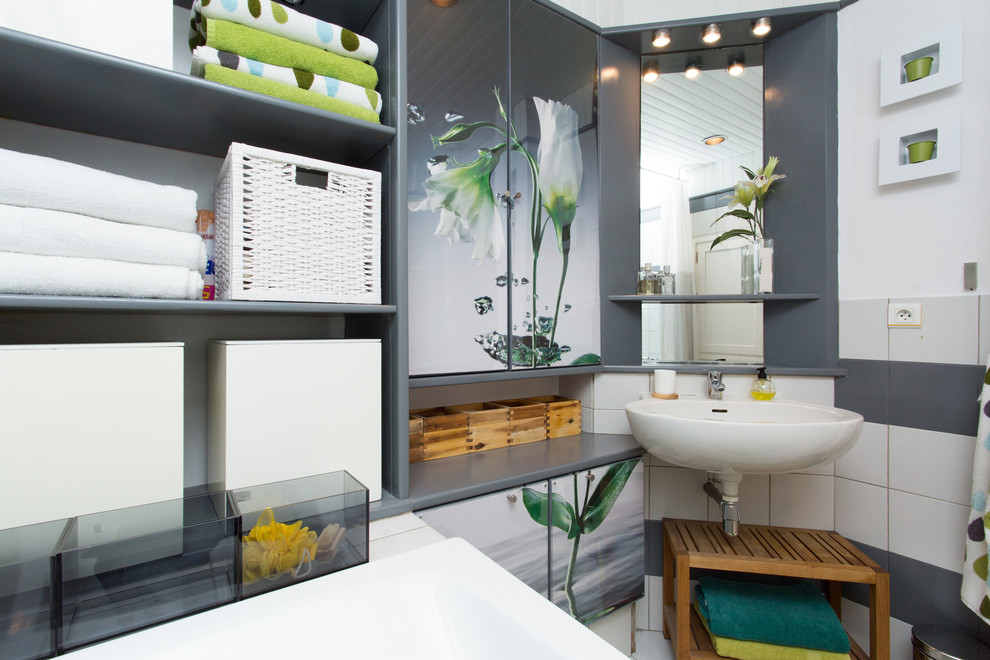 Cette photo montre une salle de bain tendance de taille moyenne avec un placard sans porte, des portes de placard grises, un carrelage beige, un carrelage gris, un mur blanc et un lavabo suspendu.