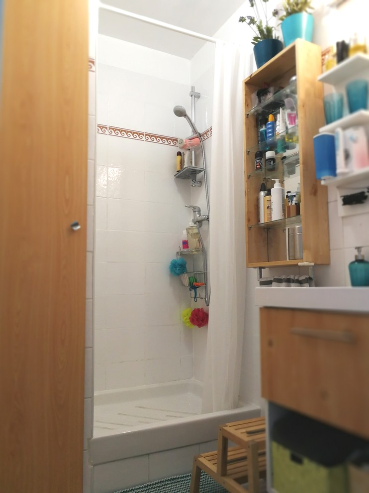 Skandinavisk inredning av ett litet badrum med dusch, med vit kakel, keramikplattor, vita väggar, klinkergolv i keramik, ett konsol handfat, beiget golv, luckor med profilerade fronter, skåp i ljust trä och en öppen dusch