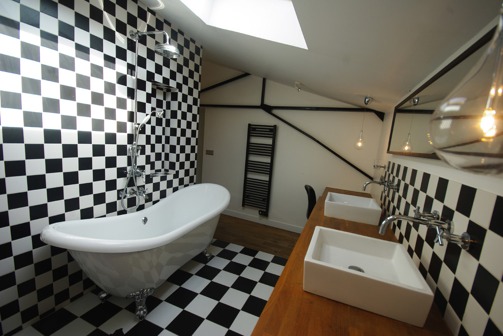 Design ideas for a medium sized contemporary ensuite bathroom in Paris with a freestanding bath, a shower/bath combination, black and white tiles, ceramic tiles, white walls, ceramic flooring, a vessel sink and wooden worktops.