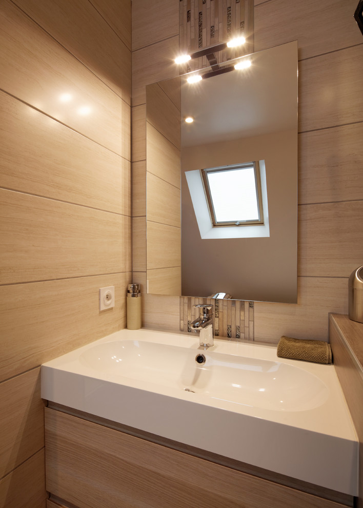 Exemple d'une salle de bain principale tendance en bois clair de taille moyenne avec un plan vasque, un placard à porte plane, un carrelage beige et un mur beige.