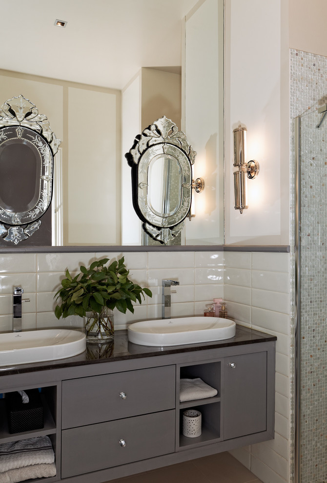 Klassisches Badezimmer mit Einbauwaschbecken, grauen Schränken, weißer Wandfarbe und Glaswaschbecken/Glaswaschtisch in Paris