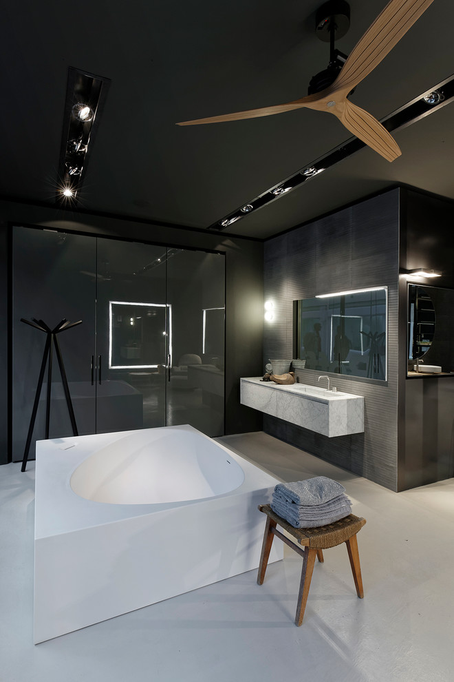 Réalisation d'une grande salle de bain principale design avec une baignoire indépendante, une douche double, un lavabo intégré et un plan de toilette en marbre.