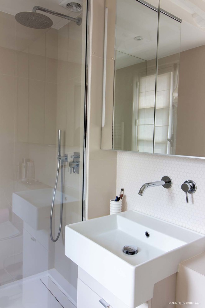 Exemple d'une petite salle d'eau tendance avec un placard à porte plane, des portes de placard blanches, une douche ouverte, WC suspendus, un carrelage beige, des carreaux de céramique, un mur beige, un sol en carrelage de céramique, un lavabo suspendu, un sol blanc, un plan de toilette en carrelage, un plan de toilette beige, une niche, meuble simple vasque et meuble-lavabo suspendu.