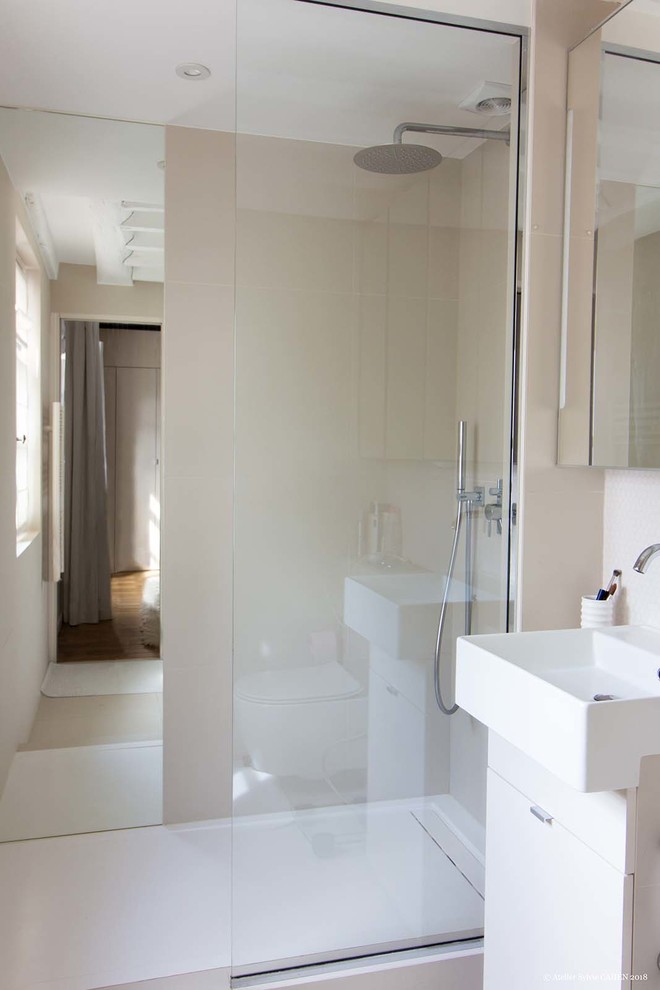 Design ideas for a small contemporary shower room bathroom in Paris with flat-panel cabinets, white cabinets, a walk-in shower, a wall mounted toilet, beige tiles, ceramic tiles, beige walls, ceramic flooring, a wall-mounted sink, white floors, white worktops, tiled worktops, a wall niche, a single sink and a floating vanity unit.