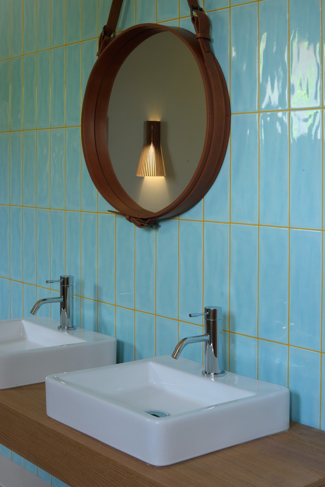Immagine di una grande stanza da bagno padronale tropicale con vasca sottopiano, doccia doppia, piastrelle blu, piastrelle in ceramica, pareti beige, pavimento con piastrelle in ceramica, lavabo sospeso e top in legno