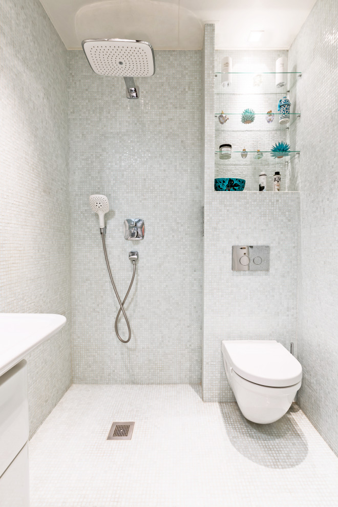 Modern inredning av ett mellanstort badrum med dusch, med släta luckor, vita skåp, en öppen dusch, en vägghängd toalettstol, vita väggar, mosaikgolv, ett undermonterad handfat, vitt golv och med dusch som är öppen