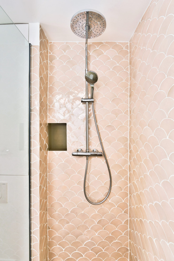 Inredning av ett shabby chic-inspirerat litet badrum med dusch, med släta luckor, vita skåp, en kantlös dusch, en vägghängd toalettstol, rosa kakel, rosa väggar, ett fristående handfat, träbänkskiva, beiget golv och med dusch som är öppen